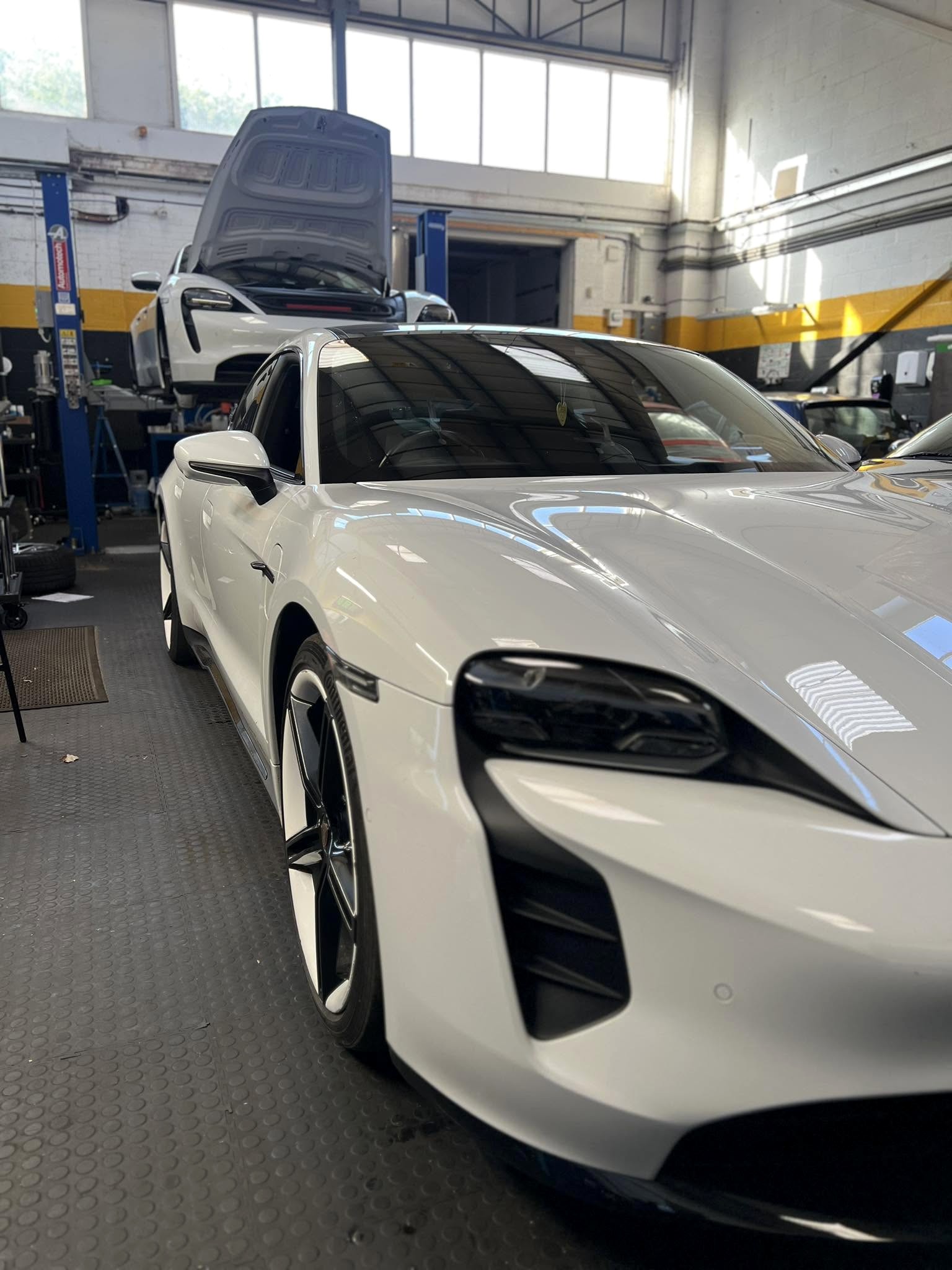 Porsche Taycan and Porsche Cayman inside SG Porsche Specialists workshop in Leicester