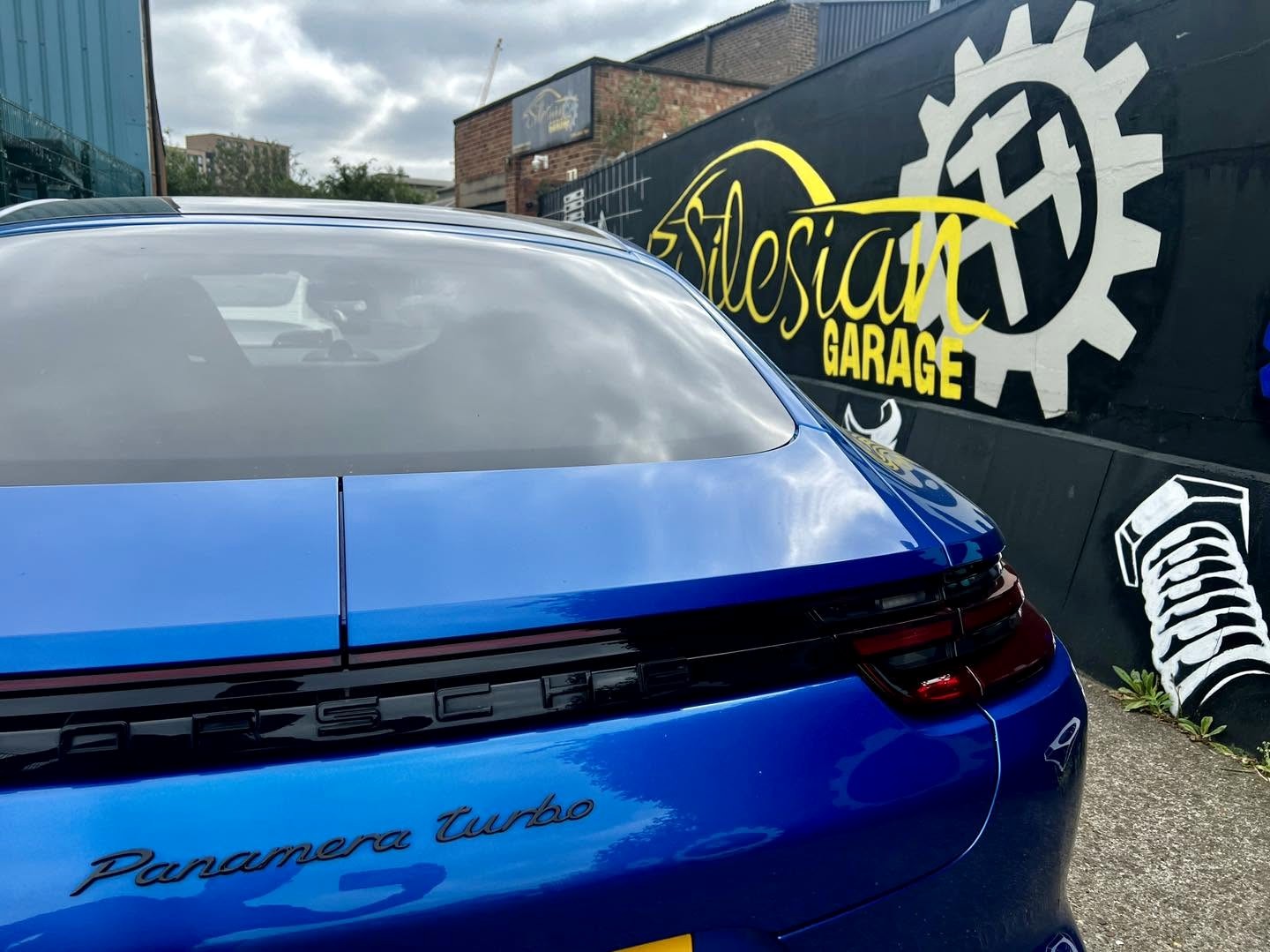 Porsche Panamera Turbo outside SG workshop mural